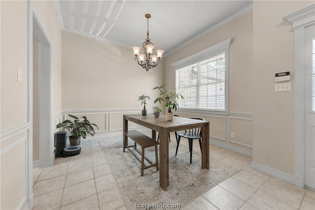 dining room with an inviting chandelier, ornamental molding, and light tile patterned flooring