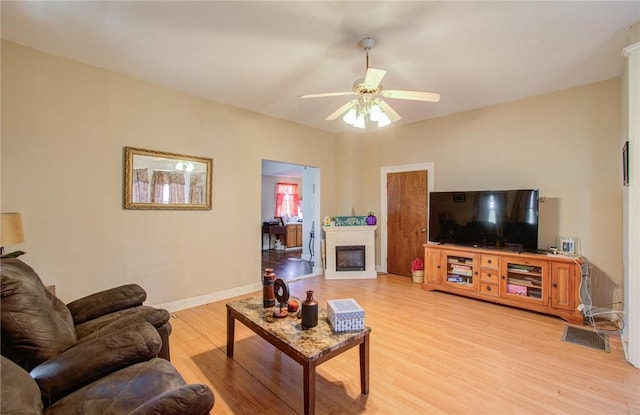 living room with ceiling fan and light hardwood / wood-style flooring