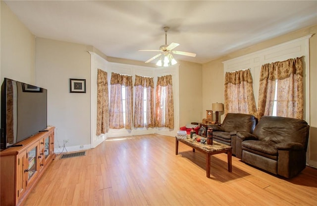 living room with light wood-type flooring and ceiling fan