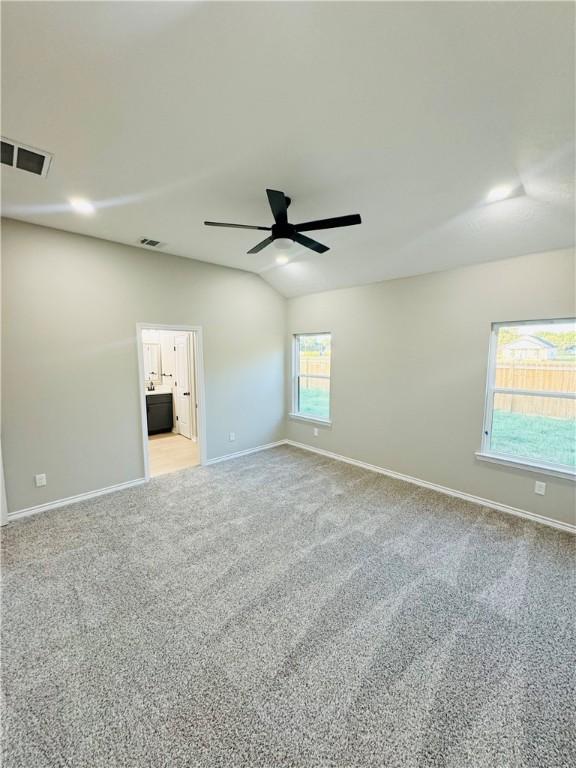 carpeted spare room with ceiling fan and lofted ceiling