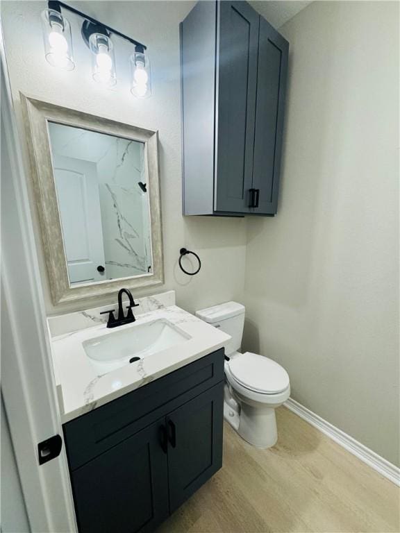 bathroom with vanity, wood-type flooring, and toilet