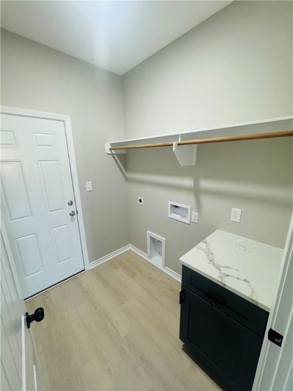 clothes washing area with cabinets, washer hookup, light hardwood / wood-style flooring, and electric dryer hookup