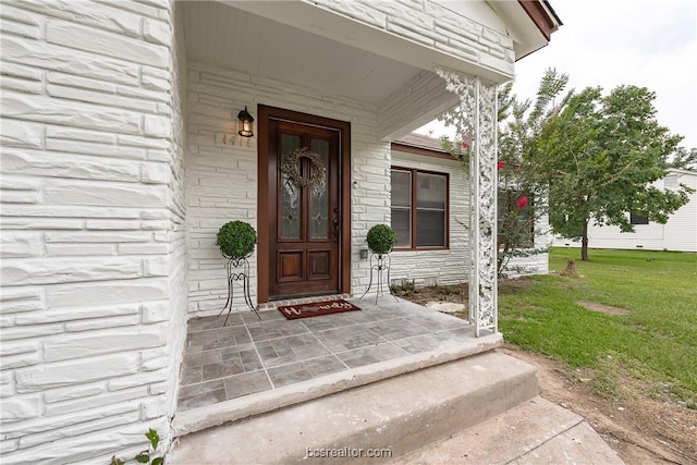 property entrance featuring a lawn