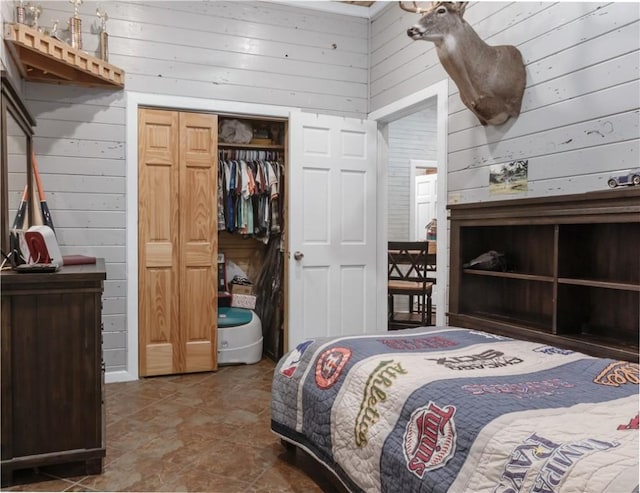 bedroom with wooden walls and a closet