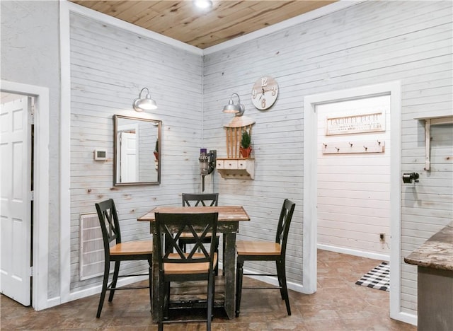 dining room with wood walls and wooden ceiling