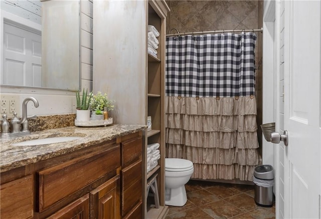 bathroom featuring curtained shower, vanity, and toilet