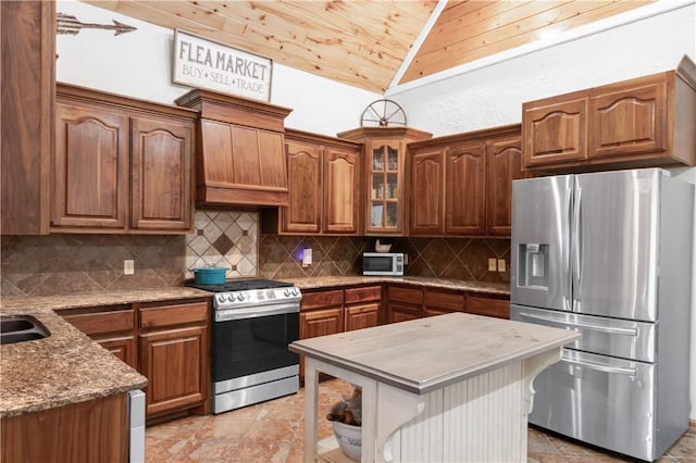 kitchen with custom exhaust hood, a center island, backsplash, light stone countertops, and appliances with stainless steel finishes