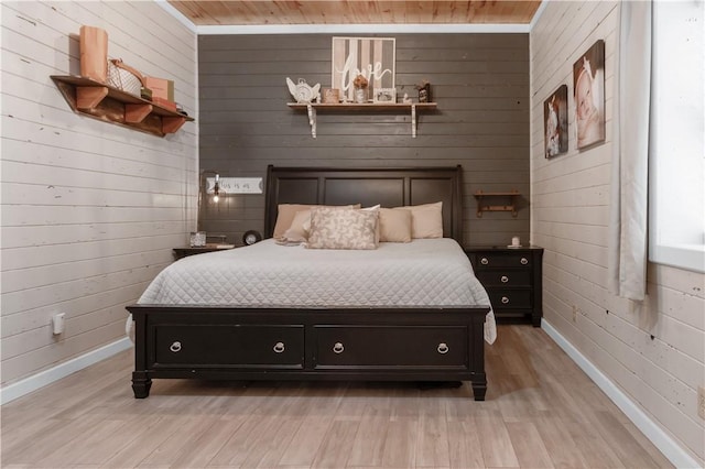 bedroom with light wood-type flooring, wooden ceiling, and wood walls