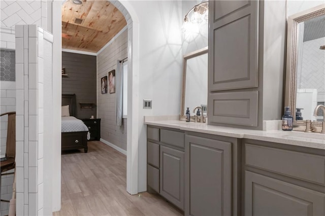 bathroom with hardwood / wood-style floors, vanity, and wood ceiling