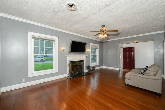 1004 S Magnolia St, Hearne, TX 77859 - living area with ceiling fan, wood finished floors, a glass covered fireplace, and crown molding
