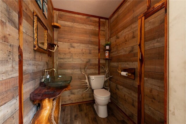 1004 S Magnolia St, Hearne, TX 77859 - bathroom with wood walls and wood finished floors