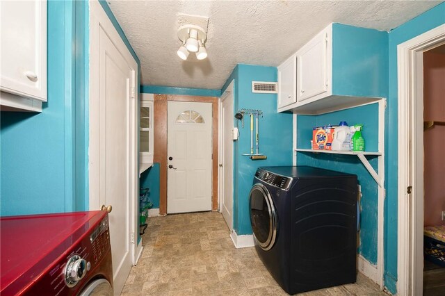 1004 S Magnolia St, Hearne, TX 77859 - washroom with separate washer and dryer, cabinet space, stone finish floors, and a textured ceiling