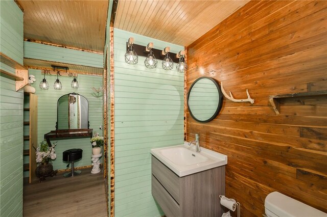 1004 S Magnolia St, Hearne, TX 77859 - bathroom with wooden walls, vanity, and wood finished floors