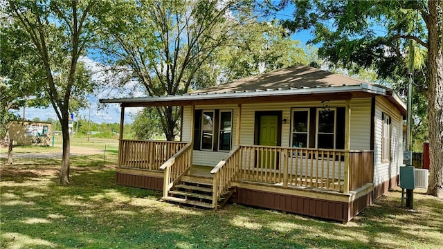 rear view of property featuring a lawn and covered porch