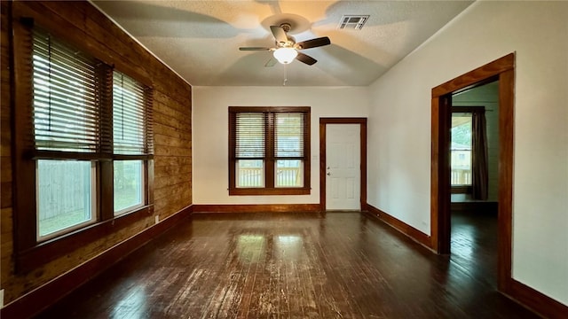 spare room with dark hardwood / wood-style flooring, a healthy amount of sunlight, and a textured ceiling