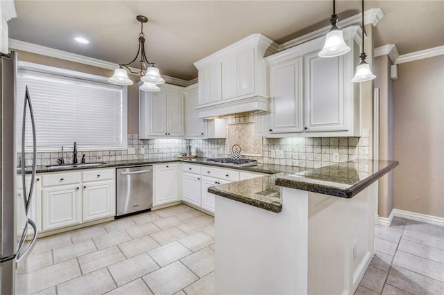 kitchen with a peninsula, ornamental molding, a sink, appliances with stainless steel finishes, and white cabinetry