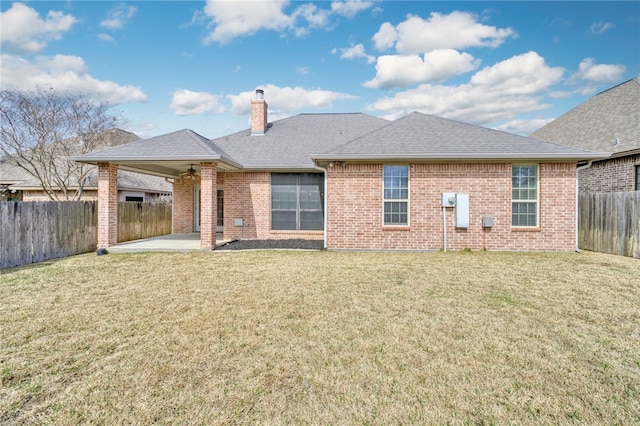 rear view of property with a patio, brick siding, a fenced backyard, and a lawn