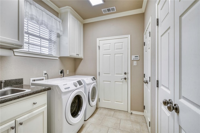 washroom with visible vents, crown molding, washer and clothes dryer, cabinet space, and a sink