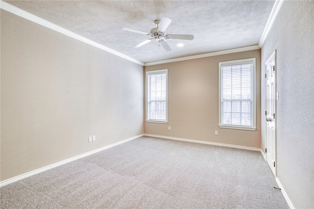 spare room featuring a textured ceiling, crown molding, baseboards, and carpet floors