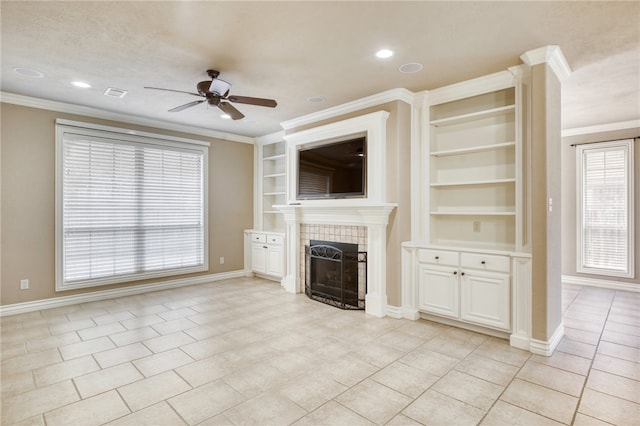 unfurnished living room with visible vents, crown molding, baseboards, ceiling fan, and a tiled fireplace