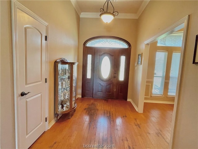 foyer featuring light wood-type flooring and crown molding