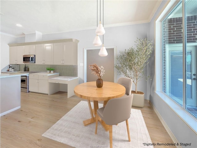 dining area with plenty of natural light, ornamental molding, and light hardwood / wood-style flooring