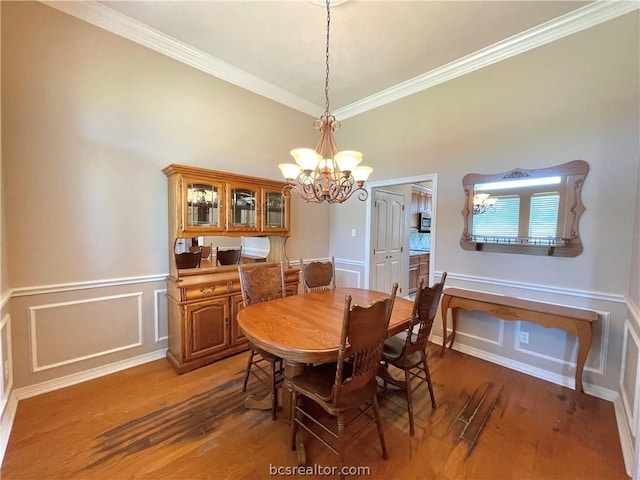 dining area with hardwood / wood-style floors, a chandelier, and ornamental molding