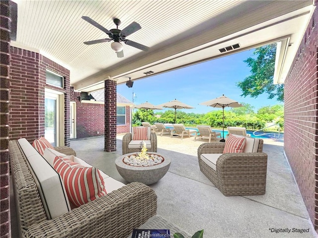 view of patio featuring ceiling fan, a swimming pool, and an outdoor living space with a fire pit