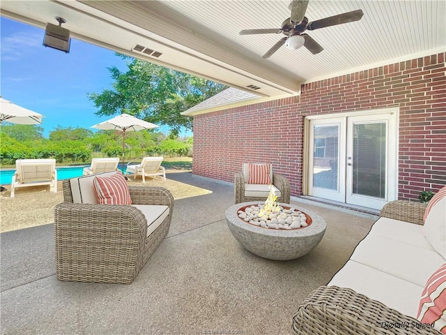 view of patio / terrace with ceiling fan, french doors, and an outdoor living space with a fire pit