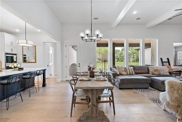 dining area with beam ceiling, light hardwood / wood-style flooring, and an inviting chandelier