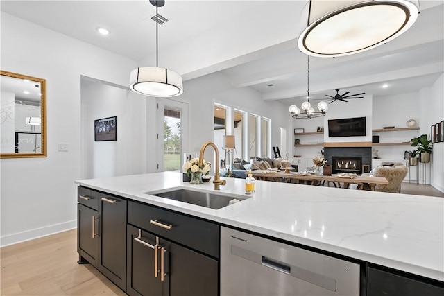 kitchen with dishwasher, sink, light stone counters, pendant lighting, and light wood-type flooring