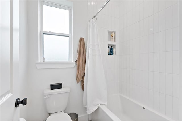 bathroom featuring shower / bath combo and toilet