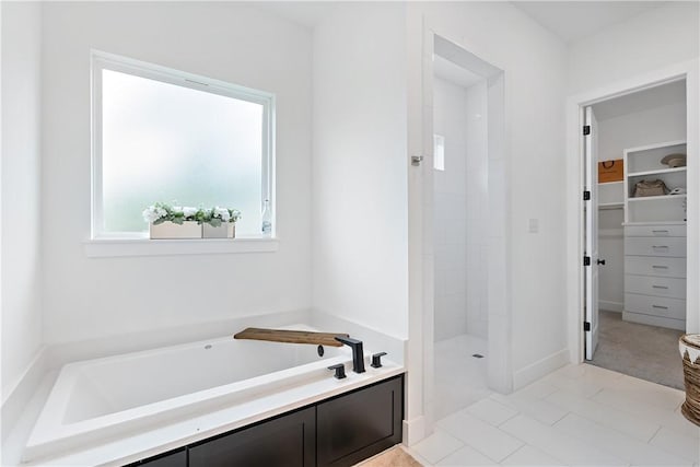 bathroom featuring tile patterned flooring and separate shower and tub