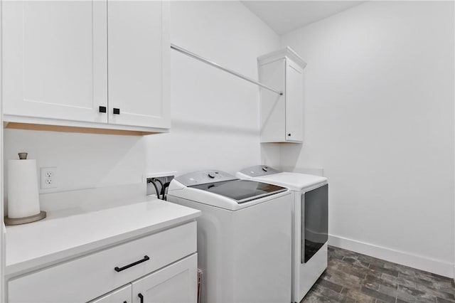 clothes washing area featuring cabinets and washing machine and clothes dryer