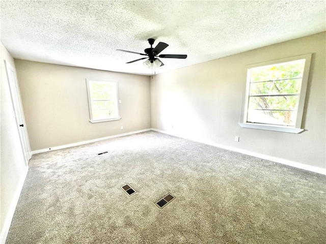 carpeted spare room featuring ceiling fan and a textured ceiling