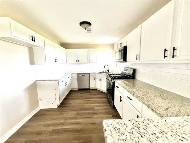 kitchen featuring dark wood-type flooring, sink, light stone counters, white cabinetry, and stainless steel appliances