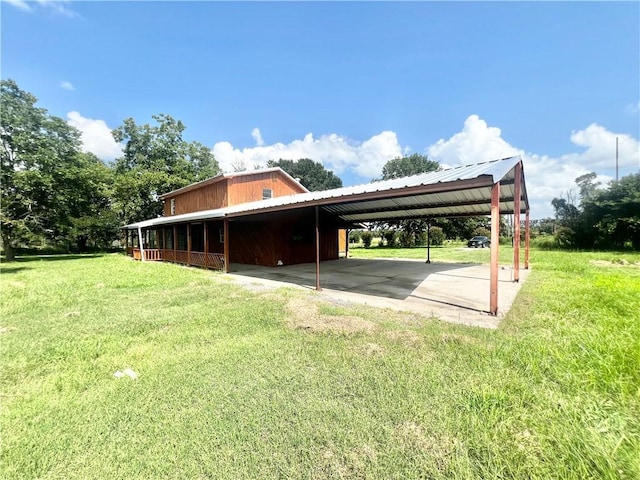 view of vehicle parking with a yard and a carport