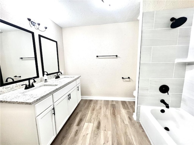 full bathroom featuring hardwood / wood-style floors, shower / bath combination, a textured ceiling, toilet, and vanity