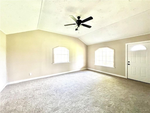 spare room featuring carpet, ceiling fan, and vaulted ceiling