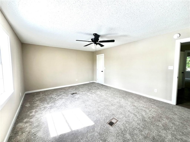 carpeted empty room featuring ceiling fan and a textured ceiling