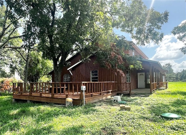 back of house featuring a lawn and a deck