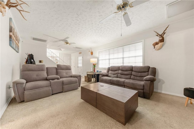 910 Briar Cliff Dr, Bryan, TX 77802 - living area with a ceiling fan, carpet floors, a textured ceiling, and stairs