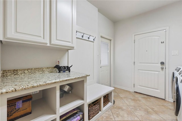 mudroom featuring independent washer and dryer, baseboards, and light tile patterned floors