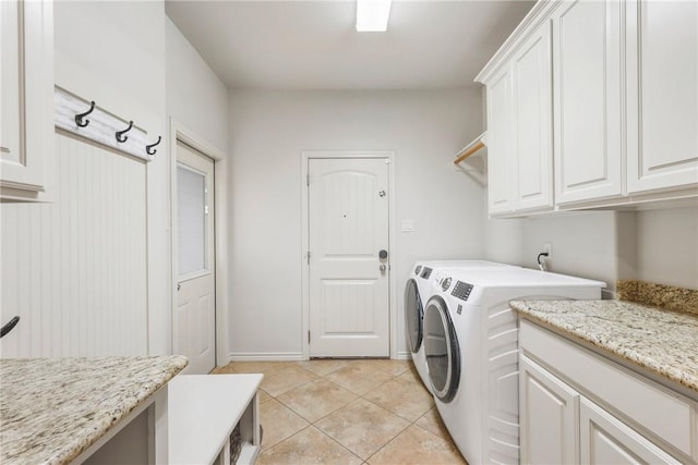 washroom with separate washer and dryer, light tile patterned flooring, cabinet space, and baseboards