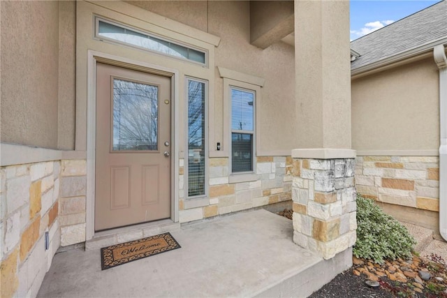 property entrance with stone siding and stucco siding