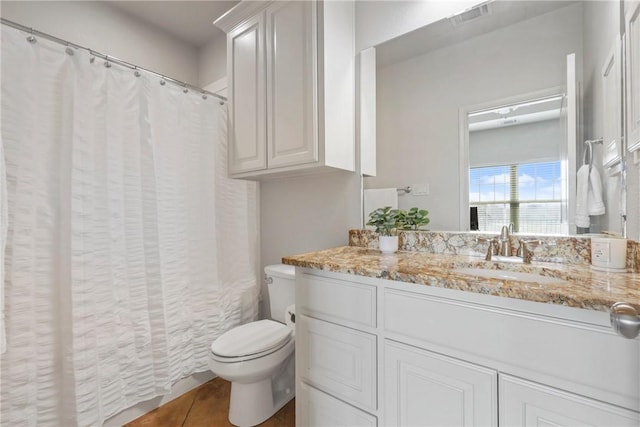 bathroom featuring toilet, curtained shower, visible vents, and vanity