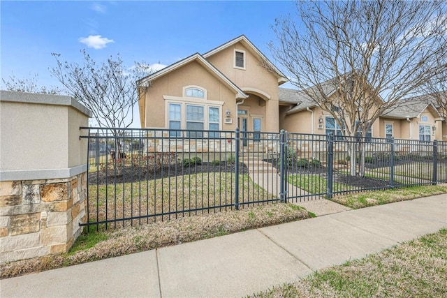 view of front of home with a fenced front yard and stucco siding