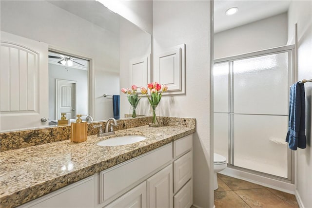 bathroom featuring toilet, a stall shower, tile patterned floors, and vanity