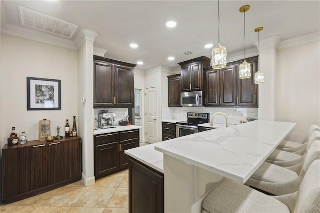 kitchen featuring stainless steel appliances, a breakfast bar, visible vents, and a peninsula