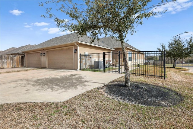 view of front of home with a shingled roof, concrete driveway, an attached garage, fence, and stucco siding